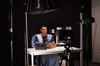 Criador digital grava um vídeo em estúdio profissional equipado com câmeras e iluminação.