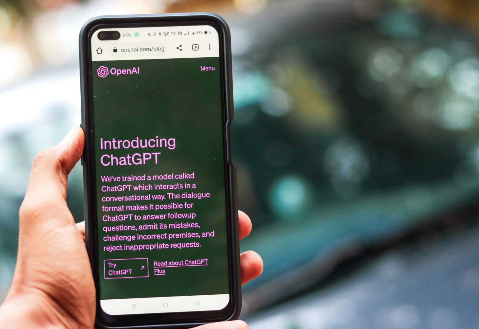 Pessoa segura um smartphone que exibe a página do ChatGPT no site da OpenAI.