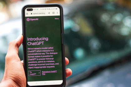 Pessoa segura um smartphone que exibe a página do ChatGPT no site da OpenAI.