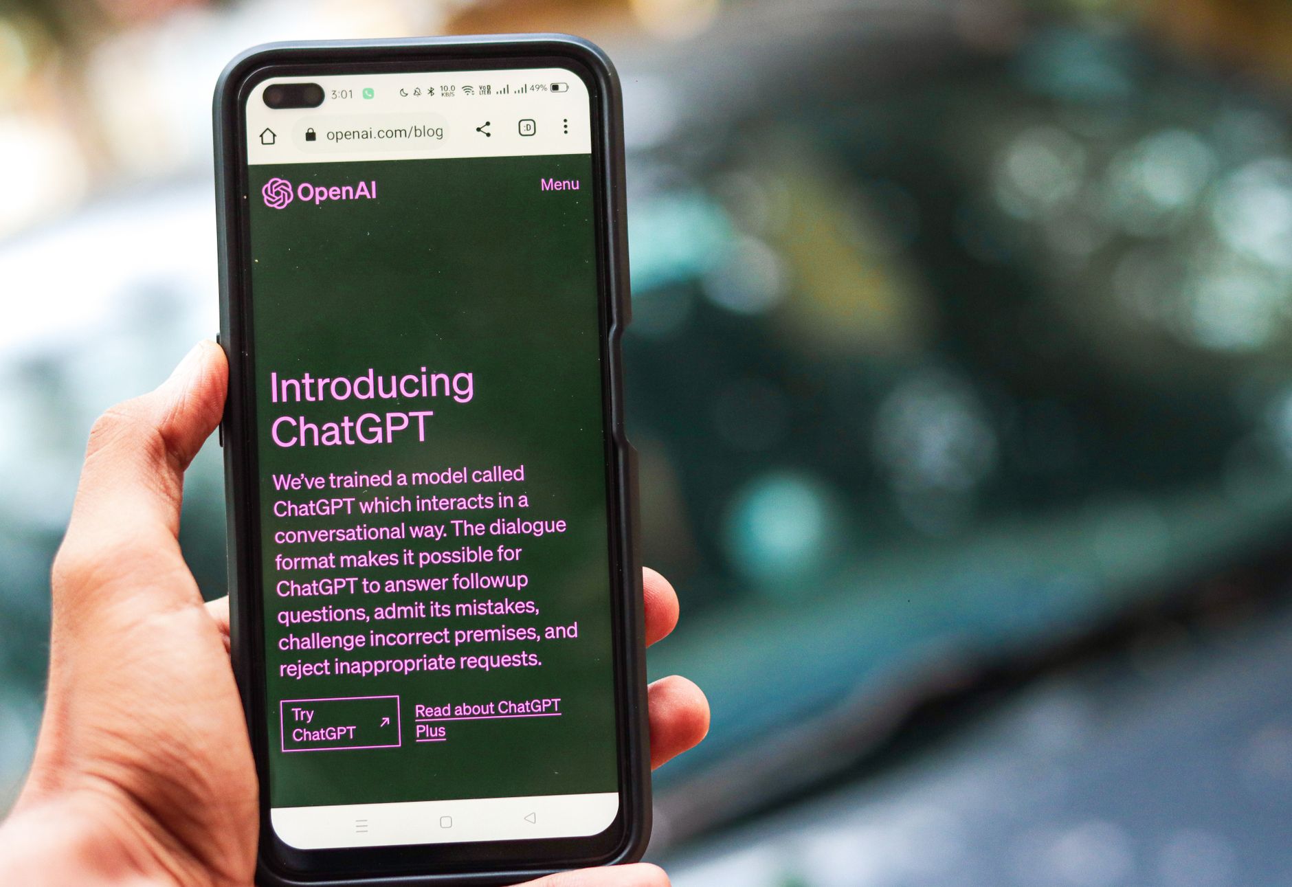 Pessoa segura um smartphone que exibe a página do ChatGPT no site da OpenAI.